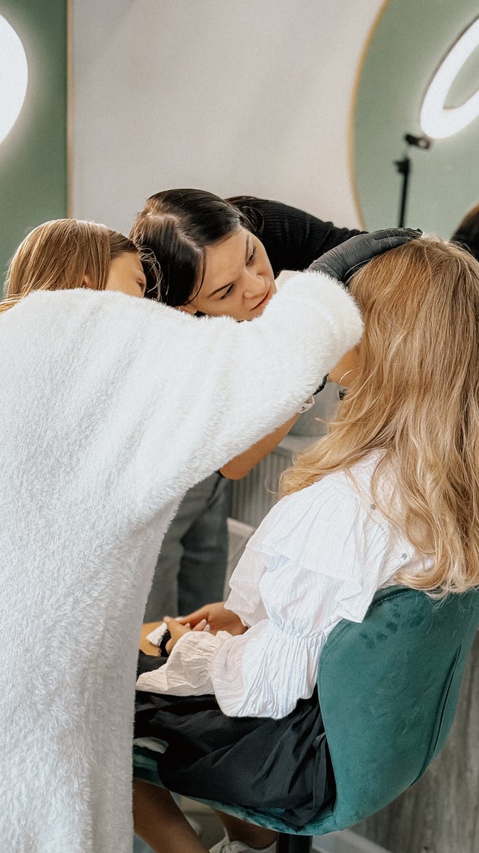 Makeup artist applying cosmetics to a client in a studio setting, creating a look.